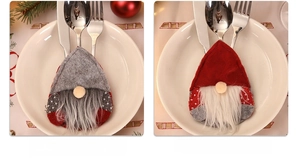 Close-up of red and grey Christmas gnome cutlery holders with festive table settings