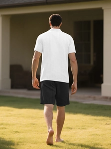 Outdoor rear view of white knit textured shirt and black casual shorts set for men