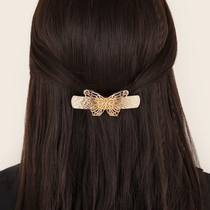 Elegant gold hollow butterfly metal hair clip worn on long brown hair from the back