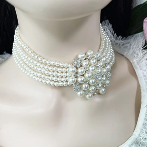 Close-up of five-layer pearl choker featuring a large rhinestone floral cluster detail