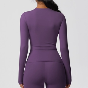 Détail du dos d'un haut de sport à manches longues violet et d'un legging aux coutures précises