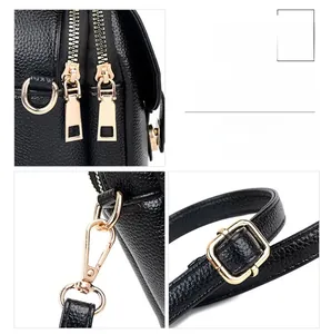 Close-up of golden metal zippers and hardware on black lychee grain leather phone bag