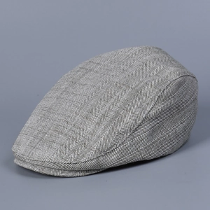 Detailed close-up of grey herringbone flat cap fabric texture and classic vintage pattern