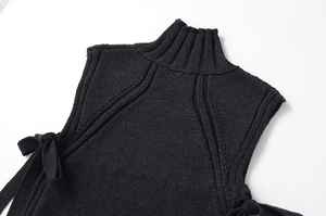 Détail rapproché d'un haut sans manches en maille noire avec col montant texturé