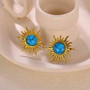 Close-up of golden sunflower stud earrings featuring sky blue faux turquoise stones