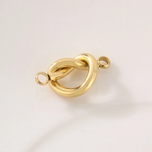 Close-up of golden stainless steel heart knot connector with double loops for DIY jewelry
