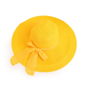 Top-down view of a bright yellow wide-brim straw hat featuring a woven spiral texture