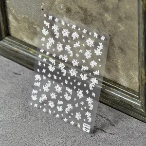Detail of 3D embossed semi-transparent white flower nail art stickers showing texture