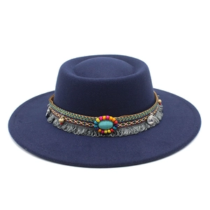 Détail du ruban ethnique avec perles colorées, franges et pierre turquoise sur chapeau