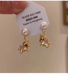 Detail view of 925 silver unicorn stud earrings with white pearls and pink wings