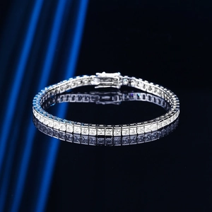 Silver tennis bracelet with square-cut cubic zirconia on reflective dark background