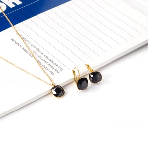 Flat lay of gold stainless steel jewelry set with square black crystal stones