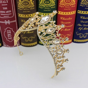 Close-up of golden Baroque crown with clear crystals on vintage book background