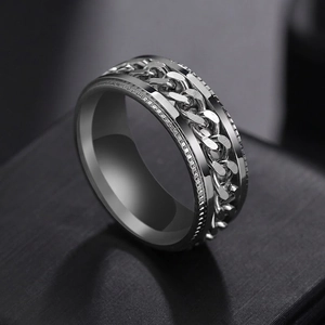 Macro shot of silver stainless steel spinner ring with rotating chain and knurled edges