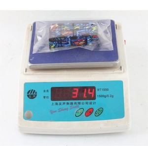 Detail shot of infinity cube weight measurement on scale showing 31.4g mass