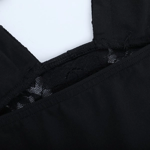 Gros plan détaillé sur la dentelle noire délicate et les coutures du col en V de la robe