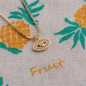 Close-up of gold plated evil eye pendant necklace with pavé cubic zirconia accents