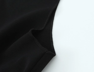 Close-up of three-needle five-thread overlock stitching on black knit fabric