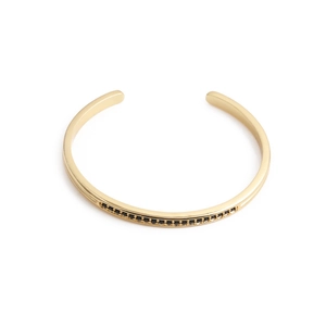 Minimalist gold C-shaped open bracelet with black zircon inlay on a white background