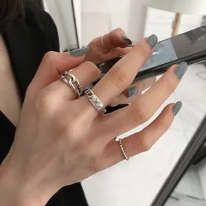 Dettaglio di un set di anelli in argento minimalisti con design a catena industriale