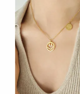 Detalle de collar de acero inoxidable chapado en oro 18K con colgantes de cara sonriente