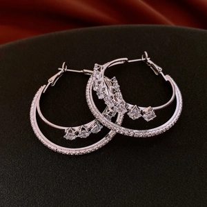 Macro shot of silver double-circle hoop earrings with sparkling cubic zirconia stones
