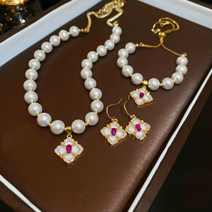 Elegant pearl jewelry set with necklace bracelet and earrings featuring red zircon charms