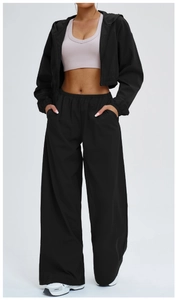 Detail of high-waisted wide-leg sports pants and black zip-up hooded sun protection jacket