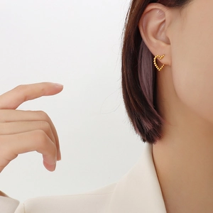 Minimalist 18k gold heart-shaped beaded stud earrings shown on model