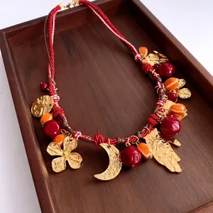 Collana bohémien in corda intrecciata con perle rosse e ciondoli dorati su legno