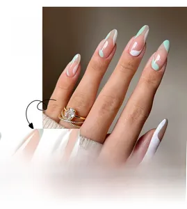 Détail de faux ongles amandes longs avec motifs abstraits ondulés verts et blancs