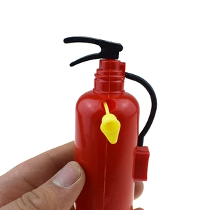 Detailed view of hand holding a red mini fire extinguisher water gun toy, nozzle close-up