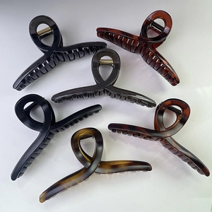Vue à plat de six grandes pinces à cheveux noir mat et écaille au design torsadé