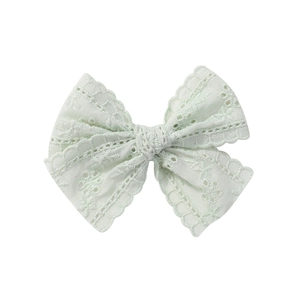 Detail of mint green lace bow hair clip featuring intricate openwork embroidery