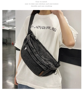 Adjustable denim crossbody bag on model featuring multiple zippered storage pockets