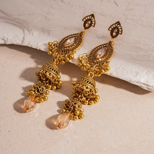 Close-up of vintage golden ethnic tassel earrings with champagne crystal rhinestones