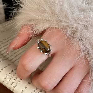 Detailed view of an oval tiger eye stone ring with vintage silver plating and textured frame