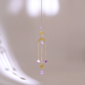 Detailed view of sun and moon crystal suncatcher with purple amethyst and gold metal
