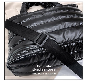 Detail showing the adjustable black textile shoulder strap and clasp on a quilted tote
