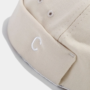 Beige canvas docker hat with white letter C embroidery in a minimalist retro style