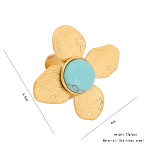 Détail macro d'une bague pétale de 4,5cm en acier doré avec pierre turquoise ronde