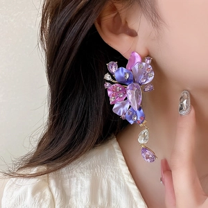 Detailed view of large vintage purple flower earrings with sparkling rhinestones and tassels
