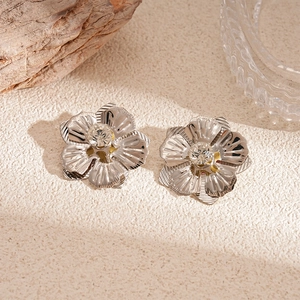 Gros plan détaillé de boucles d'oreilles fleur argentées avec centre en strass brillant