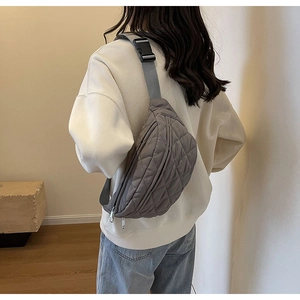 Close-up of grey quilted crossbody bag with adjustable strap and secure buckle closure