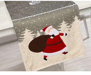 Detail of red Santa Claus print on beige cotton linen Christmas table runner