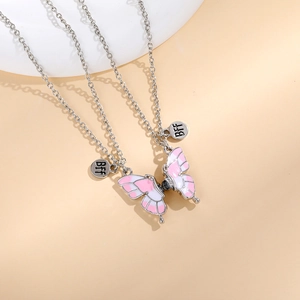 Detail of silver BFF friendship necklaces with pink and white butterfly heart pendants