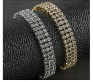 Macro shot of iced out hip hop bracelets with triple-row diamonds in silver and gold finish