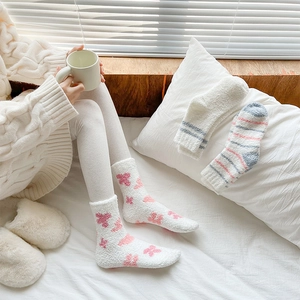 Close-up of soft coral fleece thermal socks featuring pink heart patterns and warm textures