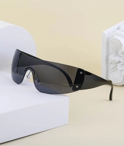 Close-up of black Y2K wraparound sunglasses on minimalist white geometric props