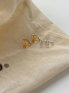 Detailed close-up of gold and silver geometric earrings with three vertical rings